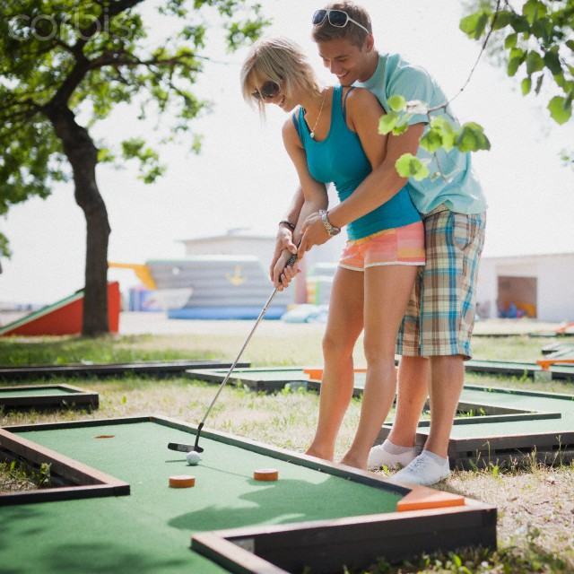 Young couple playing mini golf
